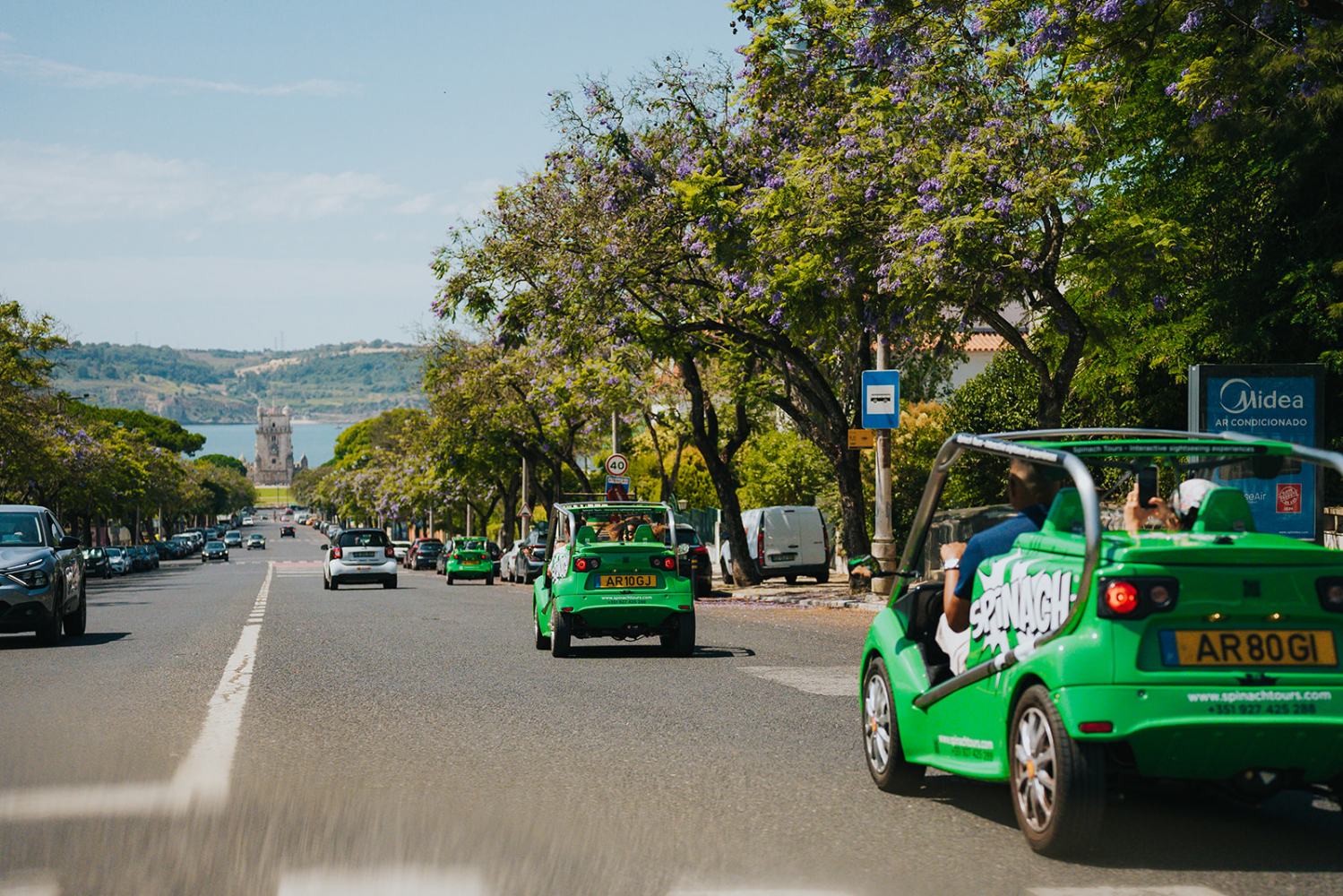 a green truck is driving down the street